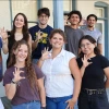 Nine of the ten 2025-2026 Mo's Policy Scholars flash Wildcat hand signs on the steps of the Udall Center